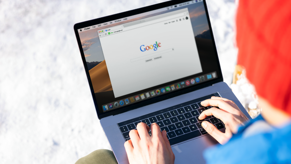Osoba z laptopem na kolanach i otwartą przeglądarką Google