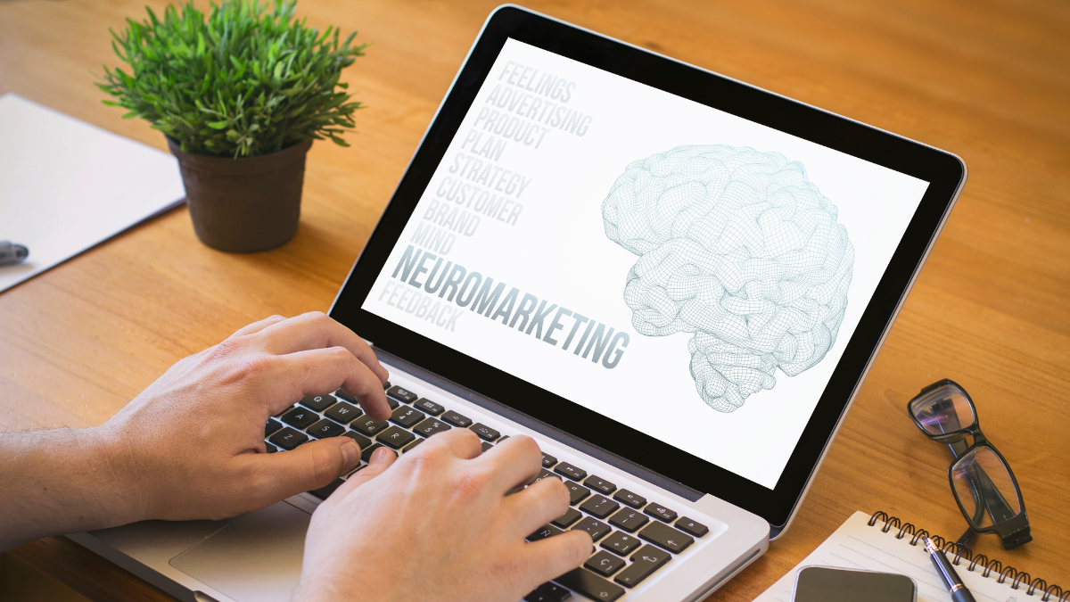 Mężczyzna używający laptopa, na którego ekranie jest napis neuromarketing i wizualizacja mózgu